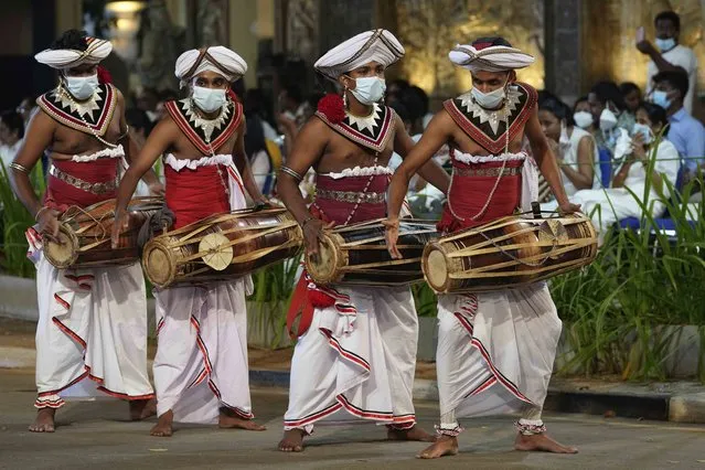 Traditional Sri Lankan drummers perform during Navam Perahera, an annual Buddhist temple festival, in Colombo, Sri Lanka, Tuesday, February 15, 2022. Buddhist monks, dancers, musicians and others participate in the festivities at famous Gangaramaya temple, one of the tourists attractions in Colombo. (Photo by Eranga Jayawardena/AP Photo)