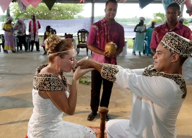 Dutch migrants Reggio de Jong and Elisabeth Cobben share coconut milk from a gourd during their wedding ceremony in the second public marriage ever held under the African-American Winti religion in district Para, Suriname, November 18, 2015. (Photo by Ranu Abhelakh/Reuters)