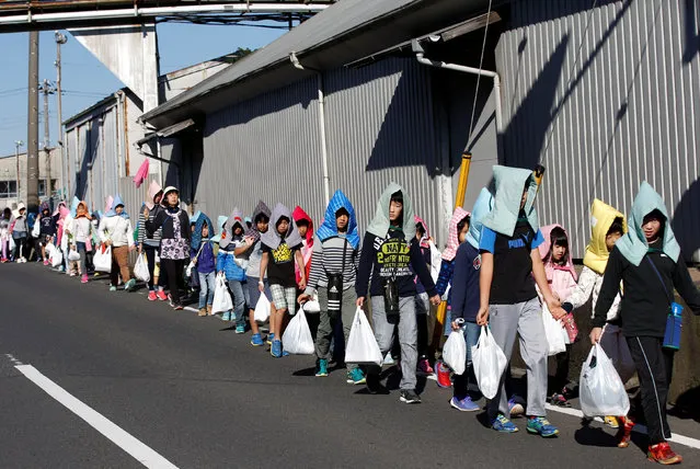 School children wearing padded hoods to protect them from falling debris make their way to an evacuation shelter on a hill during a tsunami simulation drill ahead of World Tsunami Awareness Day at Futaba elementary school in Choshi, Chiba Prefecture, Japan, November 4, 2016. (Photo by Kim Kyung-Hoon/Reuters)