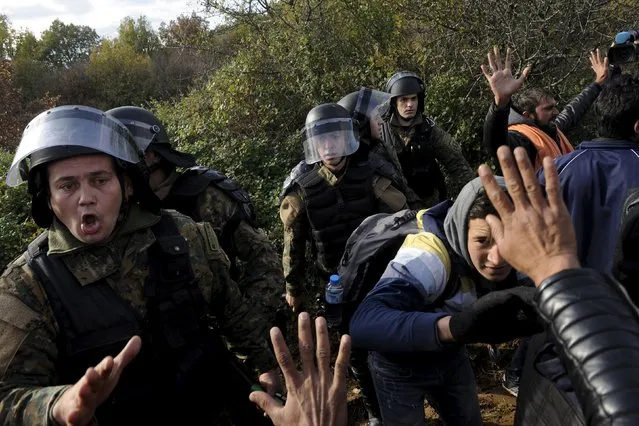 Macedonian police officers block stranded migrants trying to cross the Greek-Macedonian border, near Gevgelija, Macedonia  December 2, 2015. Picture taken from the Greek side of the border. (Photo by Alexandros Avramidis/Reuters)