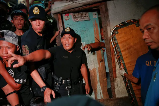Policemen try to maintain order outside a house in which five people were killed in Manila, Philippines early November 1, 2016. (Photo by Damir Sagolj/Reuters)
