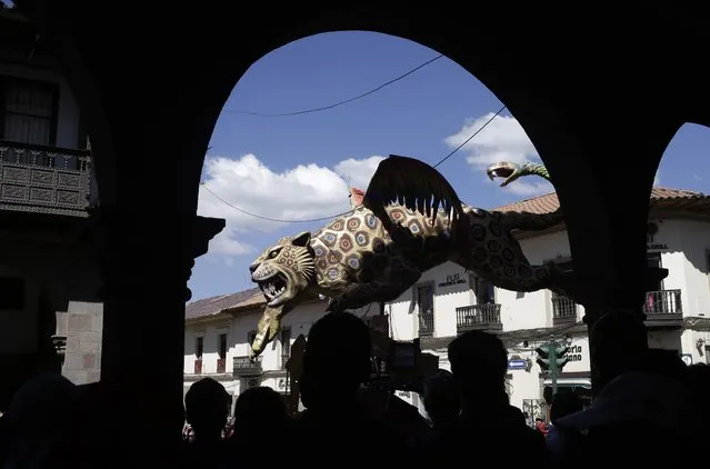 A figure of a tiger parades near the Plaza de Armas in Cusco, Peru, Saturday, June 23, 2018. June is full of festivities throughout the region of Cuzco, culminating on June 24 with the Inti Raymi, the Festival of the Sun. (Photo by Martin Mejia/AP Photo)