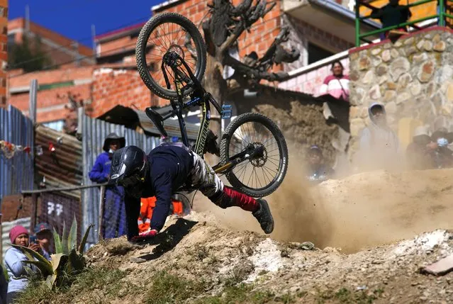 Mountain biker Carlos Barrientos tumbles off his bike during the Downhill Challenge Race, in La Paz, Bolivia, Sunday, May 21, 2023. More than 100 competitors participated in the 3.6 kilometers (2.23 miles) race, starting in El Alto and descending into La Paz. (Photo by Juan Karita/AP Photo)