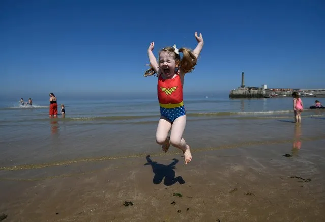 Evelyn, 4, jumps in the sea during a warm bank Holiday in Margate in Britain, 07 May 2018. The Met office has indicated this will be the hottest early May Bank holiday since records began. (Photo by Neil Hall/EPA/EFE)