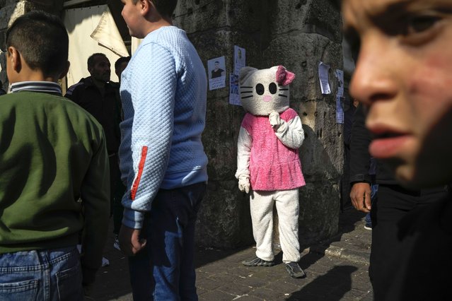 A person disguised as a cat stands in the street near the Umayyad Mosque ahead of Friday prayers in Damascus, Syria, Friday December 20, 2024. 2024. (Photo by Leo Correa/AP Phopto)