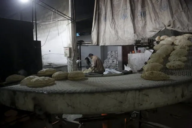 A man works inside a bakery in the rebel-controlled area of Maaret al-Numan town in Idlib province, Syria December 17, 2015. (Photo by Khalil Ashawi/Reuters)