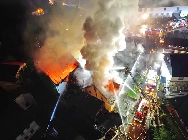 The fire department extinguishes two burning houses in the centre of Unterjeckenbach, Rhineland-Palatinate, Germany on December 4, 2020. A barn fire in Unterjeckenbach keeps the fire brigade busy on Friday morning. The exact background of the fire was initially unclear. (Photo by Sebastian Schmitt/picture alliance via Getty Images)