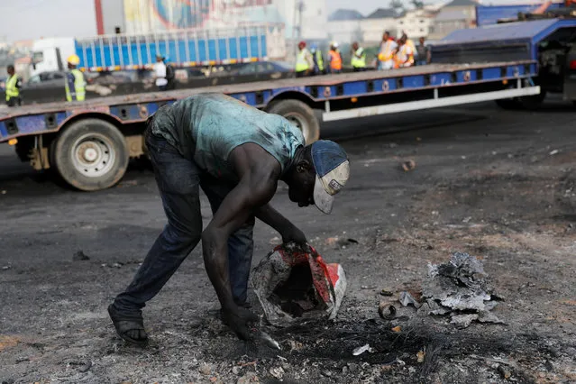 A man scanvenges for metals from debris after a fire accident involving an oil tanker along the Lagos-Ibadan expressway in the Ojodu axis of Lagos, Nigeria June 29, 2018. (Photo by Akintunde Akinleye/Reuters)