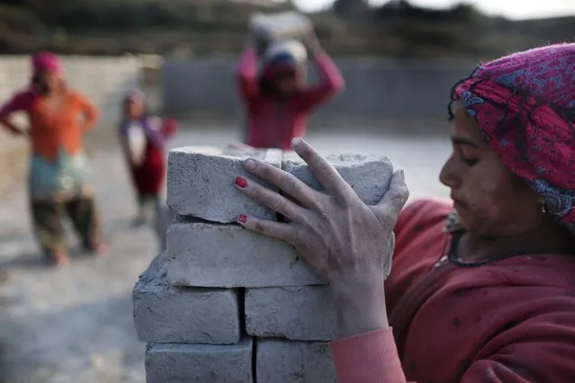 A young Nepalese laborer works at a brick factory in Lalitpur, Nepal, 21 December 2015. Thousands of Indian and Nepali seasonal migrant laborers arrive to work at brick factories around the Kathmandu valley each year during the winter and spring seasons. Some such as young laborers are forced by poverty to leave education to work at the factories. This year the demand for bricks is high in Kathmandu after more than 30 million houses were damaged due to the April Earthquake. (Photo by Narendra Shrestha/EPA)