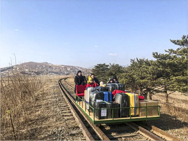 In this image taken from a video released by Russian Foreign Ministry Press Service Thursday, February 25, 2021, a group of Russian diplomats push hand-pushed rail trolley with their children and suitcases to the border with Russia. A group of Russian diplomats and their family members returned to Russia from North Korea on a hand-pushed rail trolley on Thursday because of COVID-19 restrictions in the country, Russia's Foreign Ministry said in a Facebook post. (Photo by Russian Foreign Ministry Press Service via AP Photo)