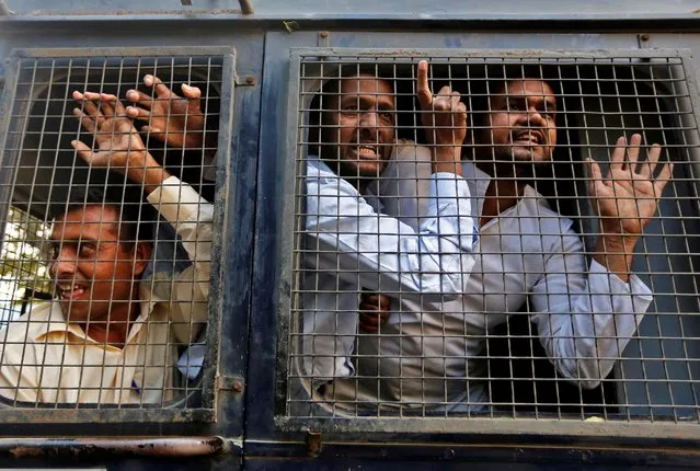 Supporters of India's main opposition Congress party shout slogans after being detained by the police during a protest against the government's decision to withdraw 500 and 1000 Indian rupee banknotes from circulation, outside the Reserve Bank of India, in Ahmedabad, India, November 19, 2016. (Photo by Amit Dave/Reuters)