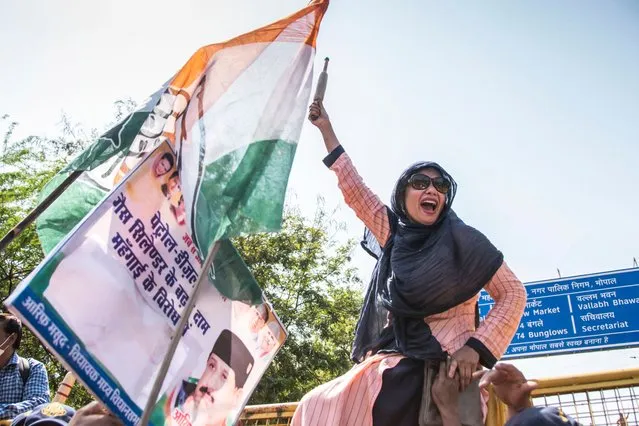 Madhya Pradesh Mahila Congress workers raise slogans during a protest against the rise in prices of commodities on International Women's Day in Bhopal, India on March 8, 2021. (Photo by Gagan Nayar/AFP Photo)