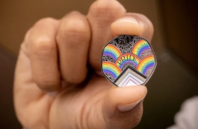 A person shows the reverse of a commemorative rainbow-coloured 50-pence coin unveiled by Britain's Royal Mint to celebrate the 50th anniversary of Pride UK, in Wales, Britain on May 6, 2022. (Photo by The Royal Mint/Handout via Reuters)