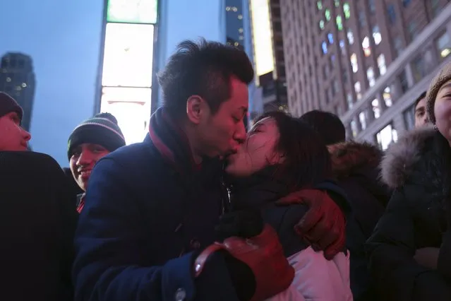 A couple kiss on the ground in a penned off area of Times Square before New Year's Eve celebrations begin in the Manhattan borough of New York, December 31, 2015. (Photo by Carlo Allegri/Reuters)