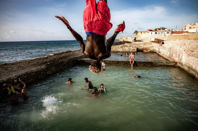 Cubans swim in a natural swimming pool off the coast of Havana on August 4, 2023. With the current hot summer, Havana residents have rushed to the dilapidated natural pools on the coast of their city, built by wealthy families in the first half of the last century. (Photo by Yamil Lage/AFP Photo)
