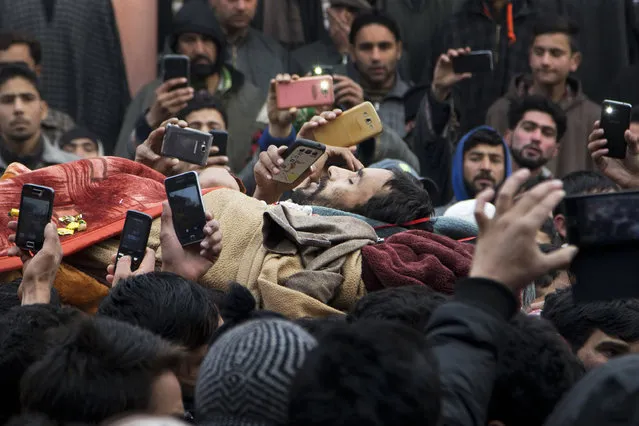 Kashmiri Muslims takes pictures with their mobile phones as they carry the body of Sajad Ahmed Bhat, a top rebel commander, during his funeral procession on the outskirts of Srinagar, Indian controlled Kashmir, Tuesday, January 12, 2016. (Photo by Dar Yasin/AP Photo)