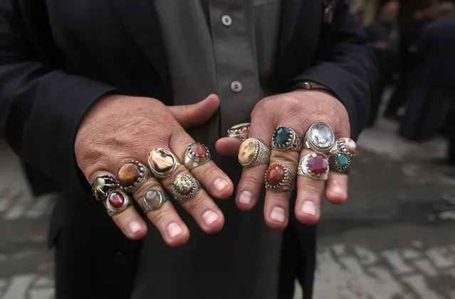 An Iraqi man displays rings for sale at an antiques market in the capital Baghdad on February 17, 2015. (Photo by Ahmad Al-Rubaye/AFP Photo)