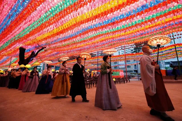 Buddhist monk and followers wearing face masks, carry lanterns to celebrate for the upcoming birthday of Buddha on May 19, while maintaining social distancing as a part of precaution against the coronavirus at the Jogye temple in Seoul, South Korea, Thursday, May 6, 2021. (Photo by Lee Jin-man/AP Photo)
