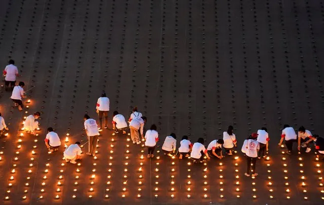 People light 330,000 candles arranged in the shape of the earth to set a Guinness World Record during Earth Day, at the Dhammakaya temple in Pathum Thani province, Thailand on April 22, 2021. (Photo by Athit Perawongmetha/Reuters)