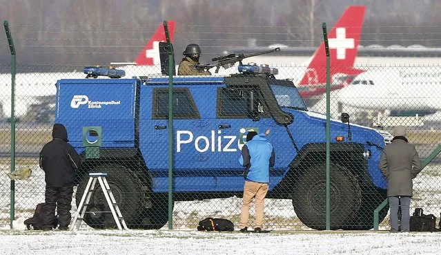 A Swiss special police vehicle drives past plane spotters at Zurich Airport, Switzerland January 21, 2016. (Photo by Arnd Wiegmann/Reuters)