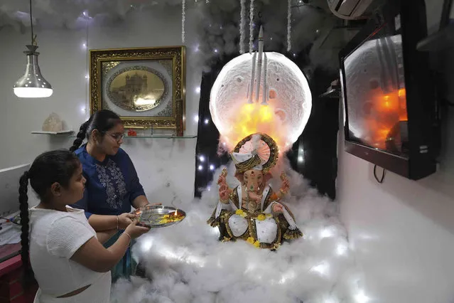 Children worship a Chandrayaan-3 themed idol of the elephant-headed Hindu god Ganesha during Ganesh Chaturthi festival in Hyderabad, India, Monday, September 18, 2023. (Photo by Mahesh Kumar A./AP Photo)