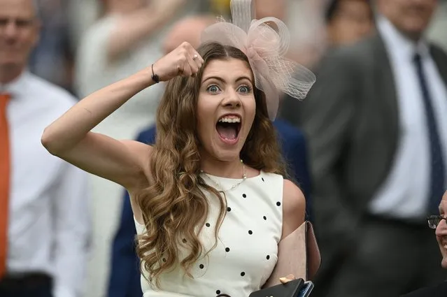 A racegoer cheers on her selection in the Hampton Court Stakes on Ladies Day at the Royal Ascot horse racing meet, in Ascot, west of London on June 17, 2021. Royal Ascot reopened its doors to 12,000 racing fans a day but the coronavirus will still take a significant financial toll on the event. (Photo by Daniel Leal-Olivas/AFP Photo)