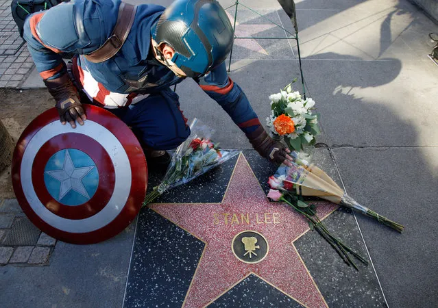 A Captain America impersonator touches the flowers covering the Walk of Fame star in memory of comic book wirter, publisher and editor Stan Lee, in Hollywood, California, USA, 12 November 2018. Lee died on 12 November at the age of 95. He is best known for being the editor-in-chief of Marvel Comics, as well as co-creating superheroes, including the Incredible Hulk, Spider-man, Black Panther and the X-men. (Photo by Eugene García/EPA/EFE)