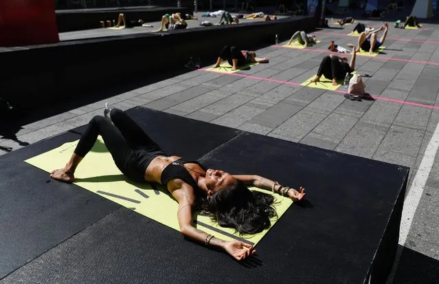 People participate in the “Solstice in Times Square: Mind Over Madness Yoga” to celebrate the summer solstice in New York, U.S. June 20, 2021. (Photo by Andrew Kelly/Reuters)