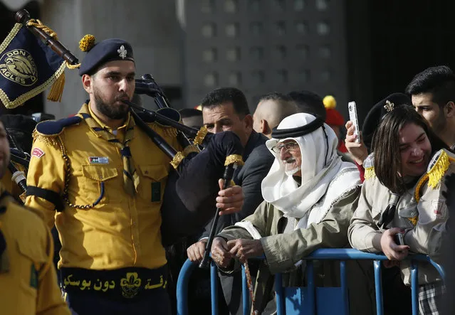 Palestinians watch a performance by Christian scouts at Manger Square, outside the Church of the Nativity, built atop the site where Christians believe Jesus Christ was born, on Christmas Eve, in the West Bank City of Bethlehem, Saturday, December 24, 2016. (Photo by Majdi Mohammed/AP Photo)