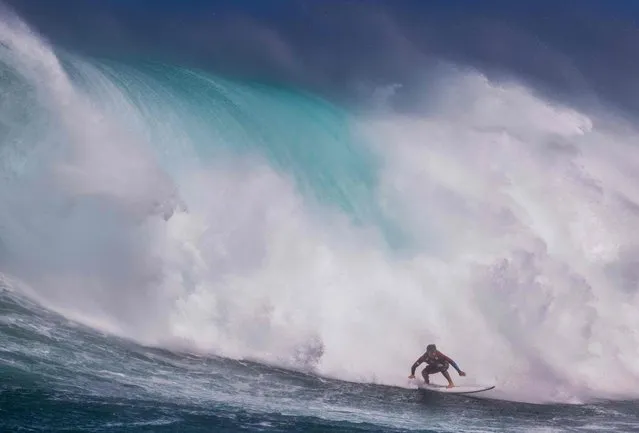 Hawaiian surfer Steve Roberson rides a wave as a big swell hits Pe?ahi surfing break, known as Jaws, on the north shore of the island of Maui, Hawaii on October 17, 2023. (Photo by Brian Bielmann/AFP Photo)