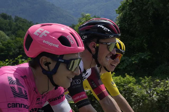 Slovenia's Tadej Pogacar, wearing the overall leader's yellow jersey, smiles as he talks with Neilson Powless of the US, left, and Denmark's Mikkel Bjerg, center, during the tenth stage of the Tour de France cycling race over 190.7 kilometers (118.5 miles) with start in Albertville and finish in Valence, France, Tuesday, July 6, 2021. (Photo by Christophe Ena/AP Photo)