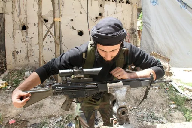 A Free Syrian Army fighter repairs a weapon at the Yarmouk Palestinian refugee camp April 29, 2015. (Photo by Ward Al-Keswani/Reuters)