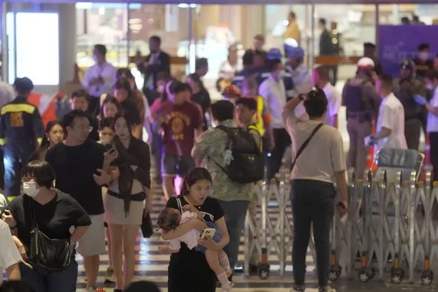 Tourists evacuate from a shopping mall in Bangkok, Thailand, Tuesday, October 3, 2023. Hundreds of shoppers fled a major shopping mall in the center of the Thai capital Bangkok on Tuesday afternoon after what sounded like gunshots were heard inside. (Photo by Sakchai Lalit/AP Photo)