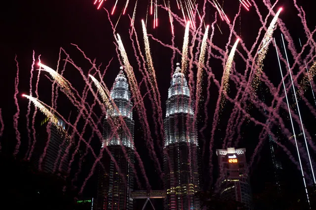 Fireworks explode in front of Malaysia's landmark building, the Petronas Twin Towers, during the New Year's celebration in Kuala Lumpur, Malaysia, Tuesday, January 1, 2019. (Photo by Yam G-Jun/AP Photo)