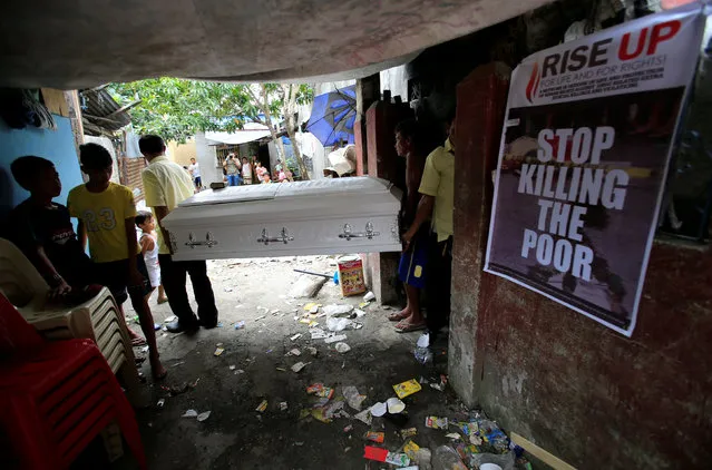 Funeral workers carry a coffrin contain the body of teenager Jonel Castro Segovia, who according to the police is one of the seven people shot dead by suspected vigilantes at a house storing illegal narcotics, during his funeral in Caloocan city, Metro Manila, Philippines January 8, 2017. (Photo by Romeo Ranoco/Reuters)