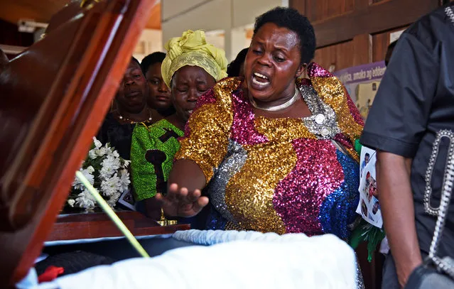 Relatives mourn near the casket of Bosco Nyanzi, who died after a cruise boat capsized in Lake Victoria off Mukono district, during his funeral service in Kampala, Uganda on November 26, 2018. (Photo by Newton Nambwaya/Reuters)