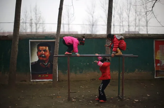 Students play next to a portrait of Soviet leader Joseph Stalin at the Democracy Elementary and Middle School in Sitong town, Henan province December 3, 2013. (Photo by Carlos Barria/Reuters)