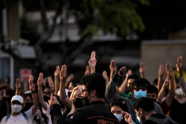 Protesters are seen giving the three-finger salutes during the anti-government gathering at the Democracy Monument in the evening on August 19, 2021 in Bangkok, Thailand. Increasingly violent protests have continued in Thailand as frustration builds over a slow vaccine rollout and record-high Covid-19 infection numbers. (Photo by Sirachai Arunrugstichai/Getty Images)