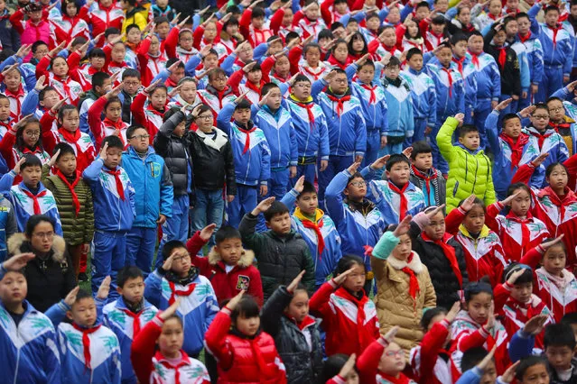 Schoolchildren salute during a flag raising ceremony on the first day of the new semester in Jiujiang, Jiangxi Province, China, February 19, 2016. (Photo by Reuters/Stringer)