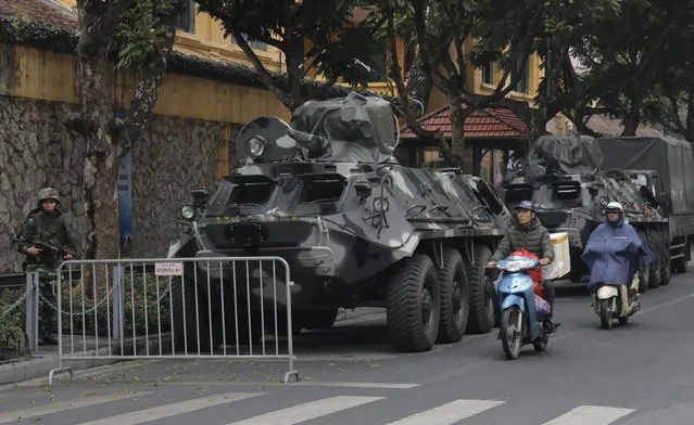 Motorists pass by army vehicles outside the Melia Hotel where North Korea leader Kim Jong Un is expected to stay at, in Hanoi, Vietnam, Tuesday, February 26, 2019. Kim arrived in Dong Dang, Vietnamese border town ahead of his second summit with U.S.President Donald Trump. (Photo by Vincent Yu/AP Photo)