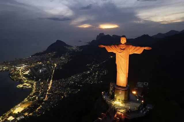 Christ the Redeemer statue is illuminated in orange to mark the “21 Days of Activism against Gender-Based Violence”, in Rio de Janeiro, Brazil, Wednesday, November 23, 2022. The landmark monument was illuminated in orange in an effort to call for the prevention and elimination of violence against women and girls. (Photo by Silvia Izquierdo/AP Photo)