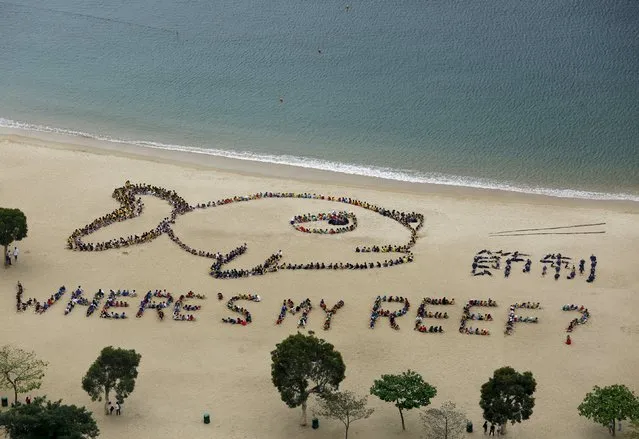 A view of over 800 school children, teachers and volunteers forming the shape of a fish with a sad expression, alongside Chinese characters that read “refrain”, at Repulse Bay in Hong Kong April 23, 2015. The event was in honor of Kids Ocean Day, to send a global message to stop consuming reef fish in order to protect the earth's coral reefs, according to the organiser. The image was originally drawn by a local seven-year-old student. (Photo by Bobby Yip/Reuters)