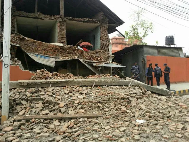 In this photo released by China's Xinhua News Agency, a collapsed building is seen in Nepal's capital Kathmandu Saturday, April 25, 2015. (Photo by Zhou Shengping/Xinhua via AP Photo)