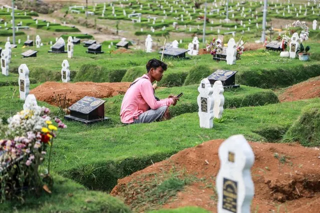 A man pay a visit to the cemetery, where the victims of the COVID-19 pandemic are buried, in Medan, North Sumatra, Indonesia, 30 September 2021. Indonesia has recorded more than 4,200,000 coronavirus disease (COVID-19) cases with more than 140,000 deaths since the beginning of the pandemic. (Photo by Dedi Sinuhaji/EPA/EFE)