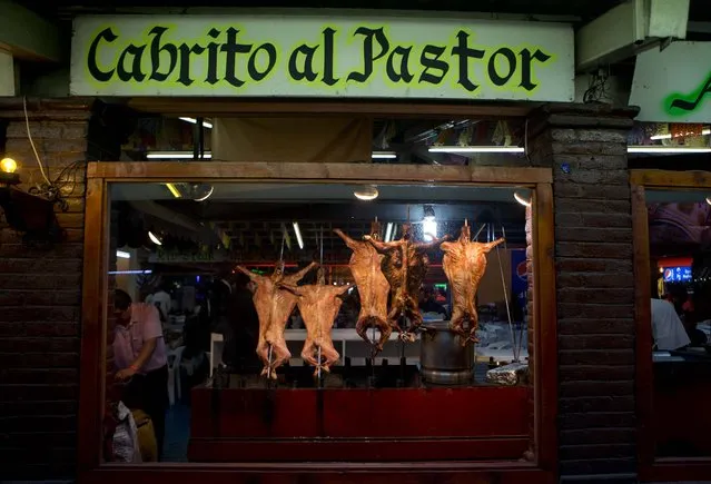 In this April 11, 2015 photo, fire roasted baby goat meat is on display at a restaurant's area of the Texcoco Fair on the outskirts of Mexico City. Although the fair began as a celebration of horses, it now resembles many county or state fairs in Mexico, with its game booths, food, beer and musical performances. (Photo by Eduardo Verdugo/AP Photo)