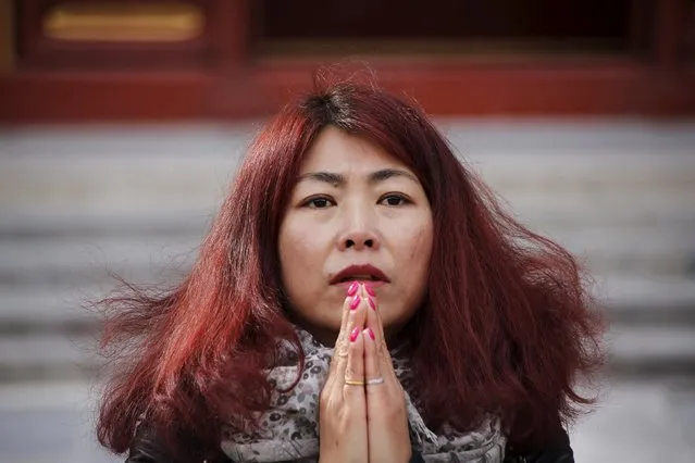 Cheng Liping prays for her husband Ju Kun, who was onboard Malaysia Airlines flight MH370 which went missing in 2014, at Lama Temple in Beijing, China, March 8, 2016. (Photo by Kim Kyung-hoon/Reuters)