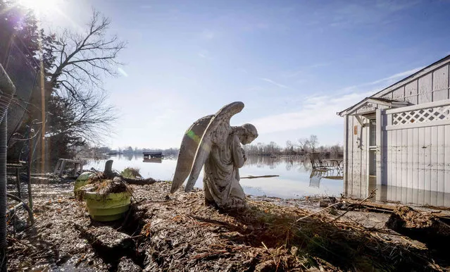 An angel statuary graces a yard near Hansen Lake Friday, March 22, 2019, in Bellevue, Neb. Residents were allowed into the area for the first time since floodwaters overtook several homes. Flooding in Nebraska has caused an estimated $1.4 billion in damage. The state received Trump's federal disaster assistance approval on Thursday. (Photo by Kent Sievers/Omaha World-Herald via AP Photo)