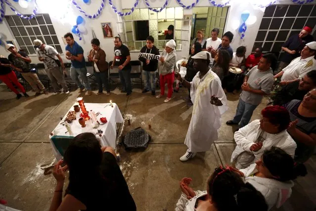 A voodoo priest and people dance during a voodoo ceremony in honor of Kouzen Zaka, also known as St. Isidro, in Mexico City, May 2, 2015. (Photo by Edgard Garrido/Reuters)