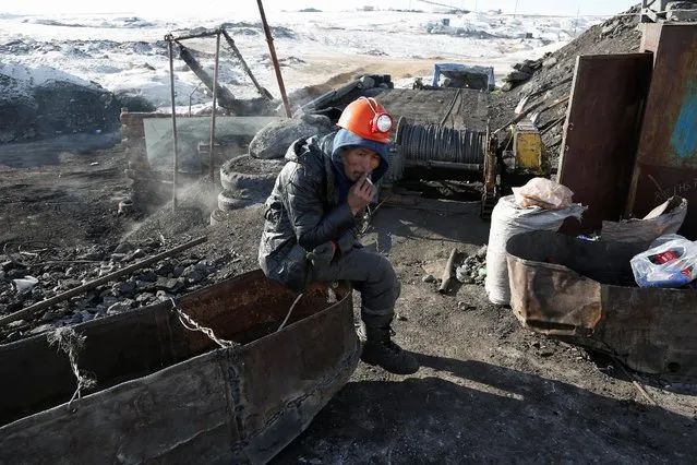 A miner smokes a cigarette at a primitive coal mine outside Ulaanbaatar, Mongolia January 27, 2017. The miners at the Nalaikh coal deposit, outside the Mongolian capital, go as much as 60 meters underground to mine the coal. (Photo by B. Rentsendorj/Reuters)
