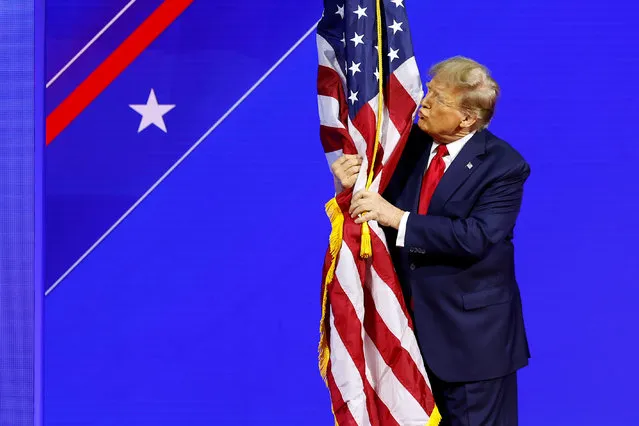 Republican presidential candidate and former U.S. President Donald Trump hugs an American flag as he arrives at the Conservative Political Action Conference (CPAC) at the Gaylord National Resort Hotel And Convention Center on February 24, 2024 in National Harbor, Maryland. Attendees descended upon the hotel outside of Washington DC to participate in the four-day annual conference and hear from conservative speakers from around the world who range from journalists, U.S. lawmakers, international leaders and businessmen. (Photo by Anna Moneymaker/Getty Images)